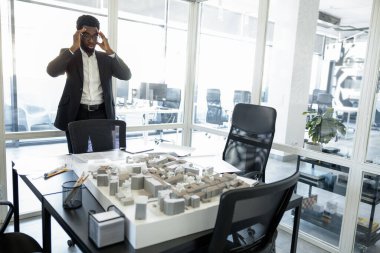 Yoğun bir iş. Ofisteki Afrikalı Amerikalı iş adamı meşgul ve düşünceli görünüyor.