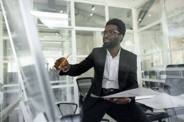 Yeni proje. Koyu tenli mimar ofisinde yeni bir proje üzerinde çalışıyor.