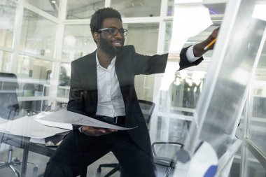 Yeni proje. Koyu tenli mimar ofisinde yeni bir proje üzerinde çalışıyor.