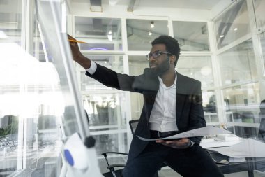 Yeni proje. Koyu tenli mimar ofisinde yeni bir proje üzerinde çalışıyor.