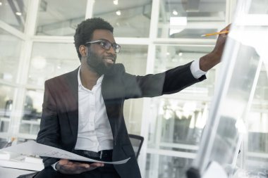 Yeni proje. Koyu tenli mimar ofisinde yeni bir proje üzerinde çalışıyor.