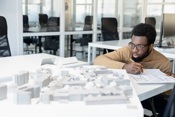 stock image Idea. African american architect thinking on a miniature and looking thoughtful