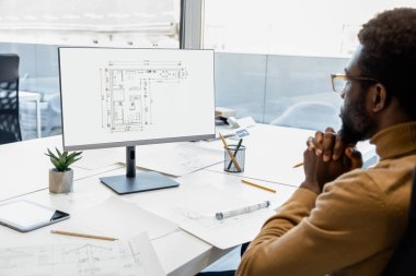 Ofisteki inşaat projelerine modern teknolojiyi katan kendinden emin bir melez mimar.