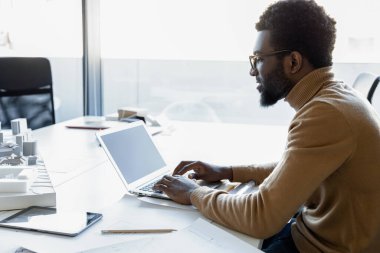 Yaratıcı çok ırklı bir mimar, bilgisayarını iş yerinde tasarım ve mimar olarak kullanır.