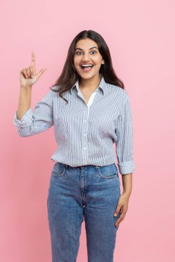 Mutlu pozitif Hintli kadın pembe arka planda mükemmel bir fikre sahip olduğunu işaret ediyor.