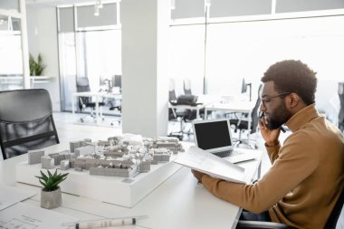Ofiste inşaat planları üzerinde çalışan yenilikçi Afrikalı Amerikalı mimar.