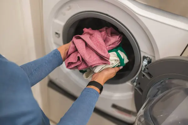 stock image Clothes washing. Woman putting clothes into the washing machine for washing