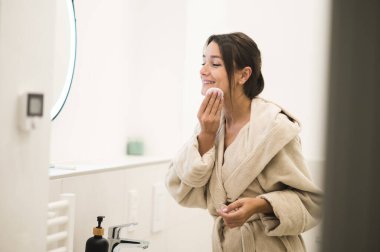 Sabah makyajı. Sıska, genç ve güzel bir kadın. Makyaj yapıyor.