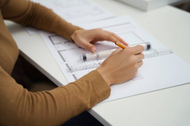 Ofiste planları olan tanınmamış bir kadın mimar.