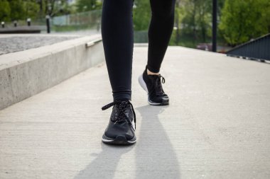 Güneşli bir sabahta stadyumda koşan tanınmayan bir kadın.