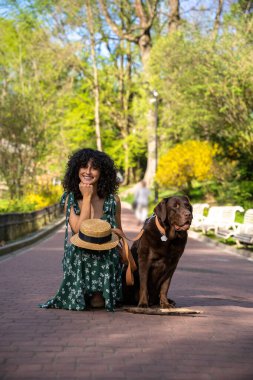 Parkta yürü. Parkta köpeğiyle uzun elbiseli güzel bir kadın.