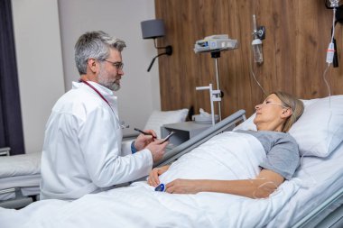 Doktor ve hasta. Doktor klinikte bir hastayla konuşuyor ve ilgili ve ilgili görünüyor.