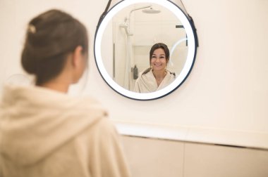 Aynada. Banyodaki aynada siyah saçlı tatlı beyaz kadın.