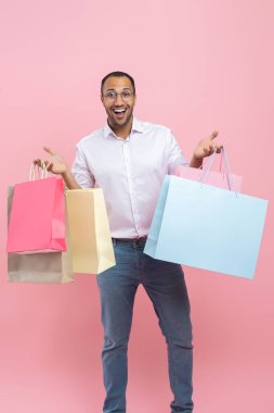 Pembe arka planda, gömlek ve gözlük takan son derece mutlu bir Afrikalı Amerikalı.