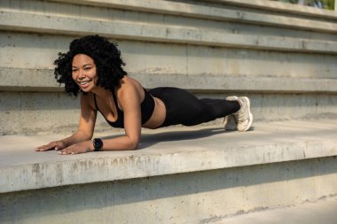 Tahtada. Tahtada duran kıvırcık saçlı atletik kadın.