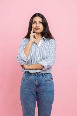 Düşünceli düşünceli Hintli kadın pembe arka planda izole edilmiş bir çene tutuyor.
