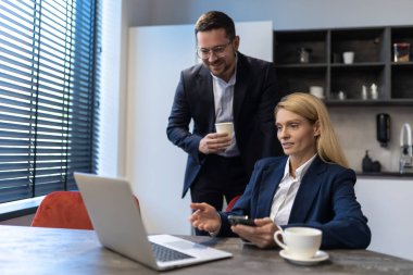 Ofisteki modern teknolojiyi kullanarak dijital projede çalışan kadın ve erkek.