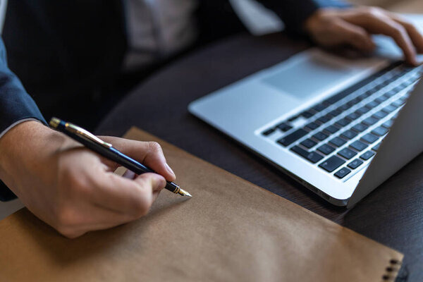 Closeup Businessman Hand Pen Writing Notes Paper While Working Laptop Royalty Free Stock Images