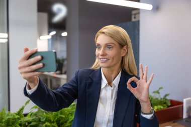 Gülümseyen iş kadını ve iş arkadaşı ofiste imzasını atıyor.