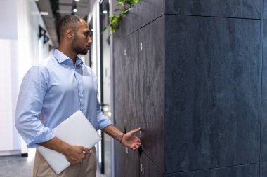Ofis salonunda dizüstü bilgisayarlı başarılı bir iş adamı.