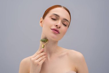 Yüz silindiri. Elinde yüz silindiri olan tatlı kızıl kadın.