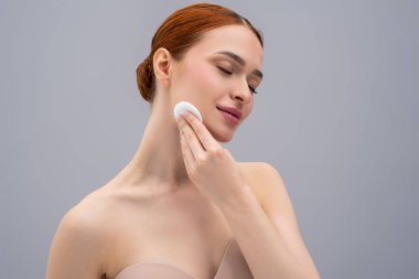 Yüz bakımı. Genç kadın yüzünü temizliyor ve rahatlamış görünüyor.