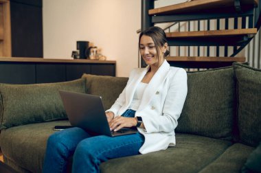 Evden çalışıyorum. Bilgisayarı evde çalışan genç ve güzel bir iş kadını.