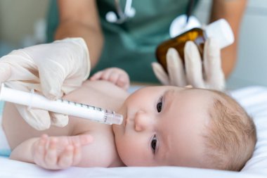 Sağlık kliniğine gittiği sırada hasta çocuğa ilaç veren isimsiz bir hemşire.