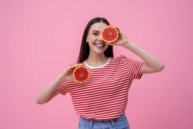 Happy woman. Pretty happy young woman in striped tshirt with part of grapefruit in hand clipart