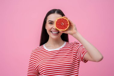 Happy woman. Pretty happy young woman in striped tshirt with part of grapefruit in hand clipart