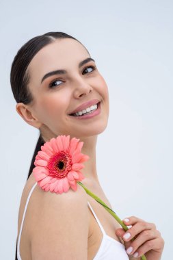 Uyum. Elinde çiçekle güzel, narin, genç bir kadın. Rahatlamış görünüyor.