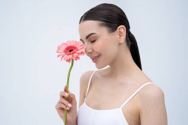 Uyum. Elinde çiçekle güzel, narin, genç bir kadın. Rahatlamış görünüyor.