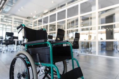 Engelliler için modern boş tekerlekli sandalye. Ofisin iç odasına ya da konferans salonuna park edilmiş.