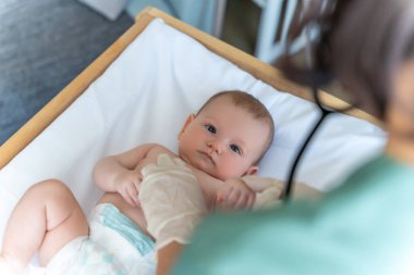 Bebek doktor muayenesinde ve steteskoplu doktor çocuğu muayene ediyor.