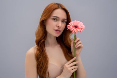 Femininity. Pretty sweet young woman with a pink flower in hand clipart