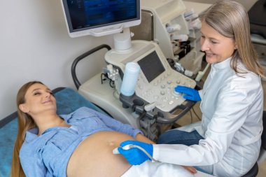 Hamilelik. Üçüncü ayındaki hamile kadın klinikte ultrasonografi yaptırıyor.