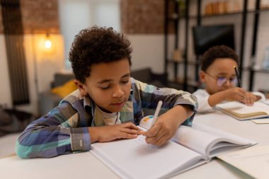 Ev ödevi. İki çocuk ders yapıyor gibi görünüyor.