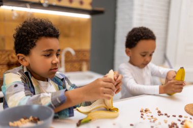 Sağlıklı kahvaltı. İki kardeş masada oturuyor ve kahvaltı yapıyorlar.