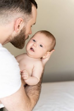 Bekar baba evde tek başına bebeğe bakarken yeni doğmuş çocuğu öpüyor.