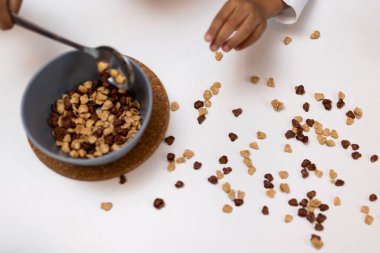 Dökülmüş mısır gevreği. Dökülmüş mısır gevreği olan bir masanın resmini kapat.