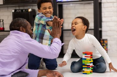 Maç zamanı. Afrika kökenli Amerikalı bir aile yerde oturup Jenga oynuyor.