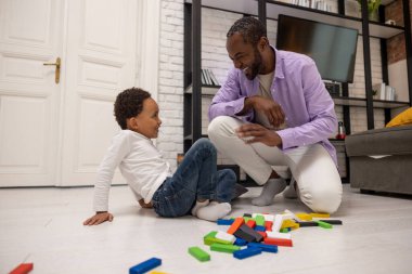 Hafta sonu evde. Baba ve oğul birlikte Jenga oynuyor ve eğleniyorlar.