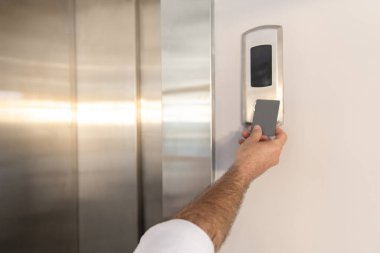 Kapı kontrolü. Ofisteki kapıyı kilitleyip açmak için elinde sahte anahtar tutan bir adam.