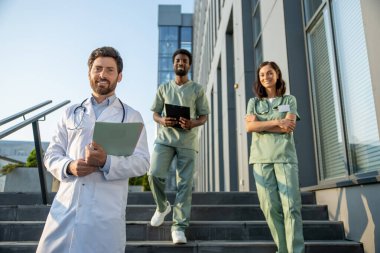 Doktorlar iş başında. Genç doktorlar klinik geçmişinde pozitif ve kendinden emin görünüyorlar.