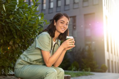 Morning coffee. Young female doctor having coffee in the morning after a night shift clipart