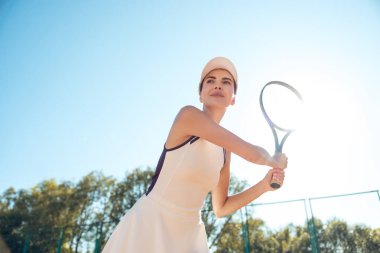 Tenis oynuyordum. Genç bayan tenisçi kortlarda oynarken konsantre ve odaklanmış görünüyor