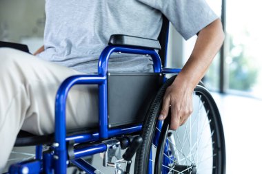 Rehabilitasyon. Rehabilitasyon merkezinde tekerlekli sandalyede oturan gri tişörtlü bir kadın.