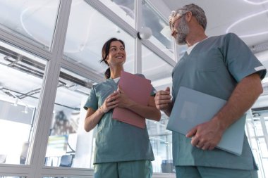 Klinikte. Klinik koridorunda yürüyen ve konuşan iki doktor.