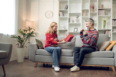 Mutlu bir çift. Mutlu çift Noel için hediyelerini değiş tokuş ediyor ve eğleniyorlar.