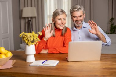 Görüntülü arama. Gülümseyen olgun bir çift görüntülü arama yapıyor.
